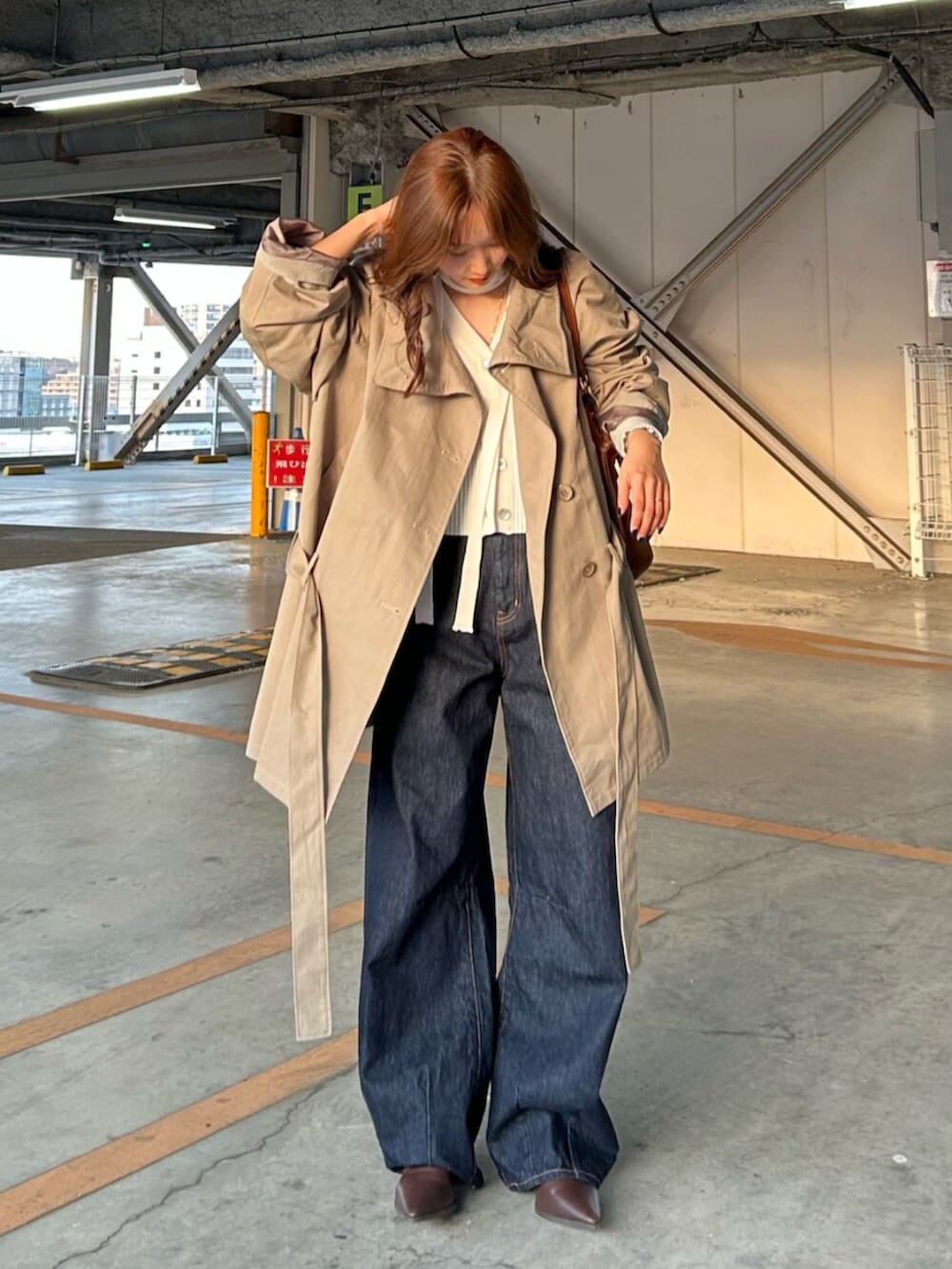 ブルー系のデニムパンツ、グリーン系のトレンチコート、ホワイト系のカーディガン/ボレロを着用したレディースの春コーディネートの4枚目の写真