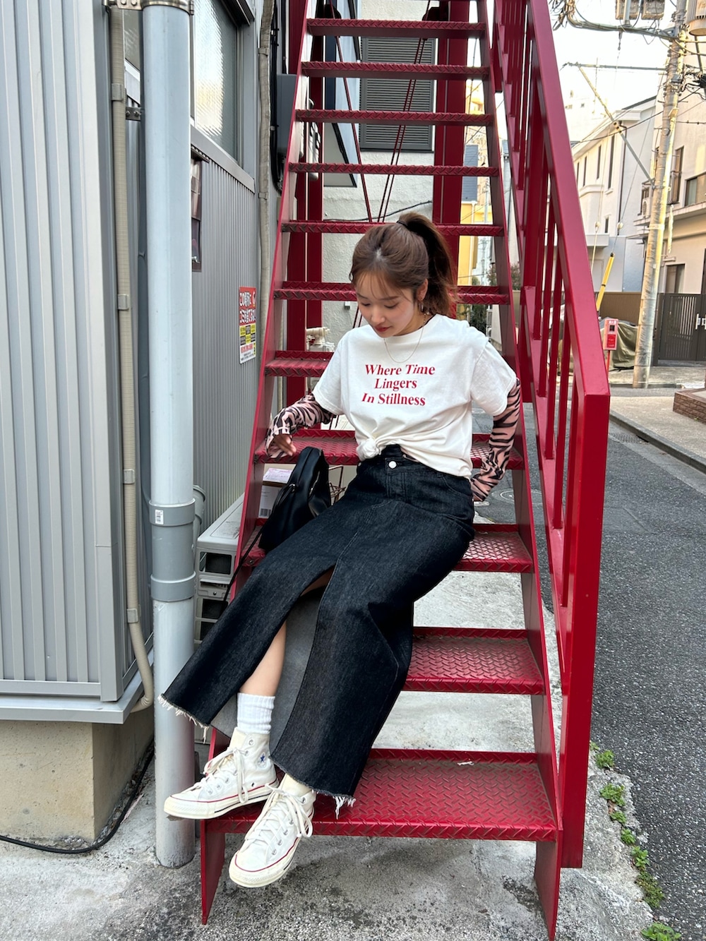 ブラック系のTシャツ/カットソー、ホワイト系のTシャツ/カットソー、ブラック系のスカートを着用したレディースの春コーディネートの9枚目の写真