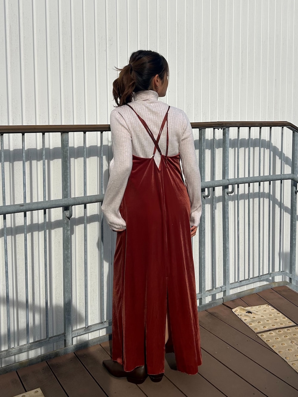 レッド系のワンピース、ホワイト系のニット/セーター、ブラウン系のブーツを着用したレディースの冬コーディネートの3枚目の写真
