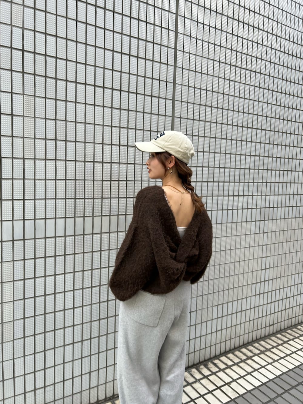 ホワイト系のスニーカー、ブラウン系のニット/セーター、グレー系のその他パンツを着用したレディースの秋コーディネートの6枚目の写真