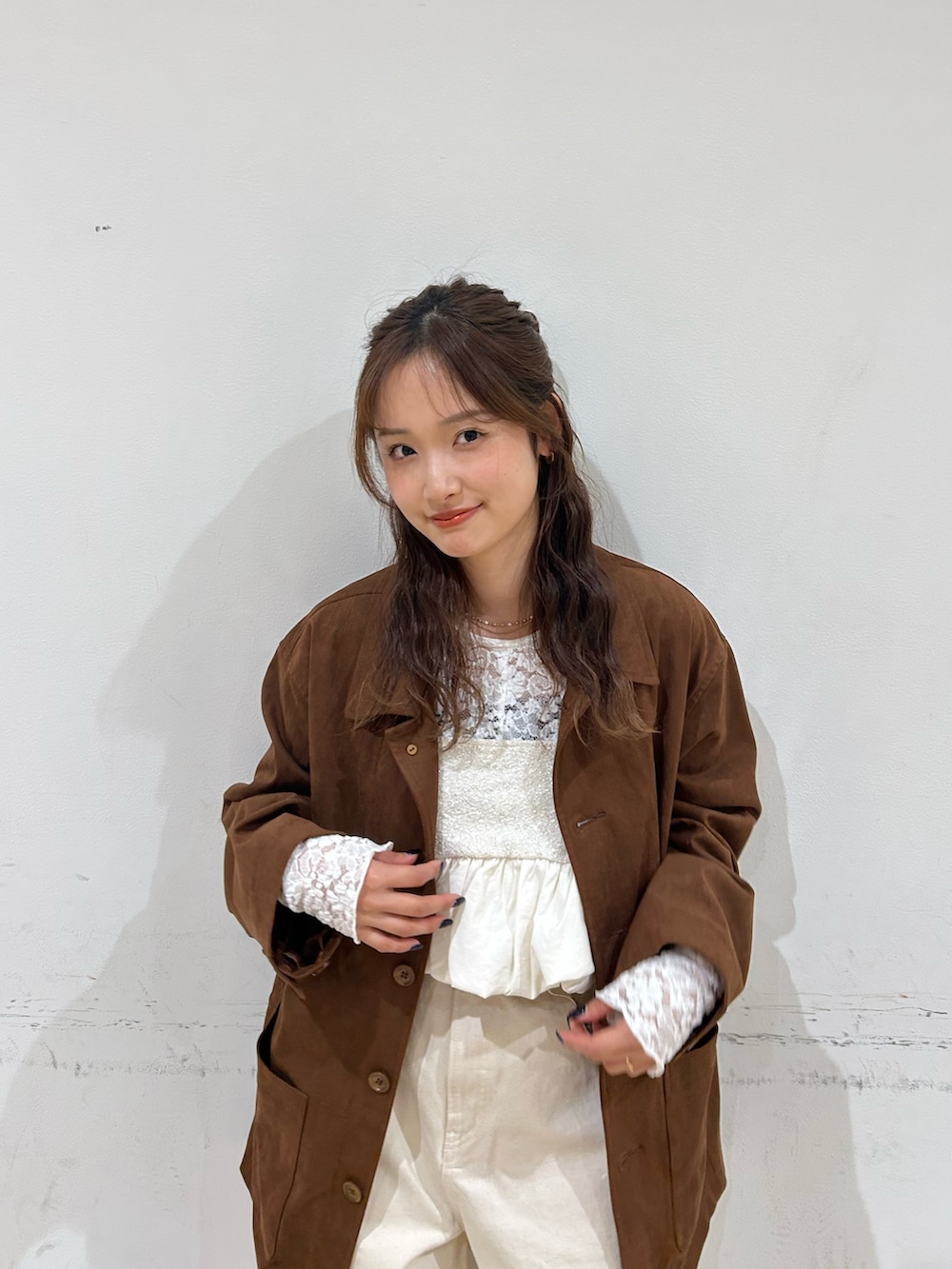 ブラウン系のテーラードジャケット、ホワイト系のパンプス、ホワイト系のデニムパンツを着用したレディースの冬コーディネートの6枚目の写真