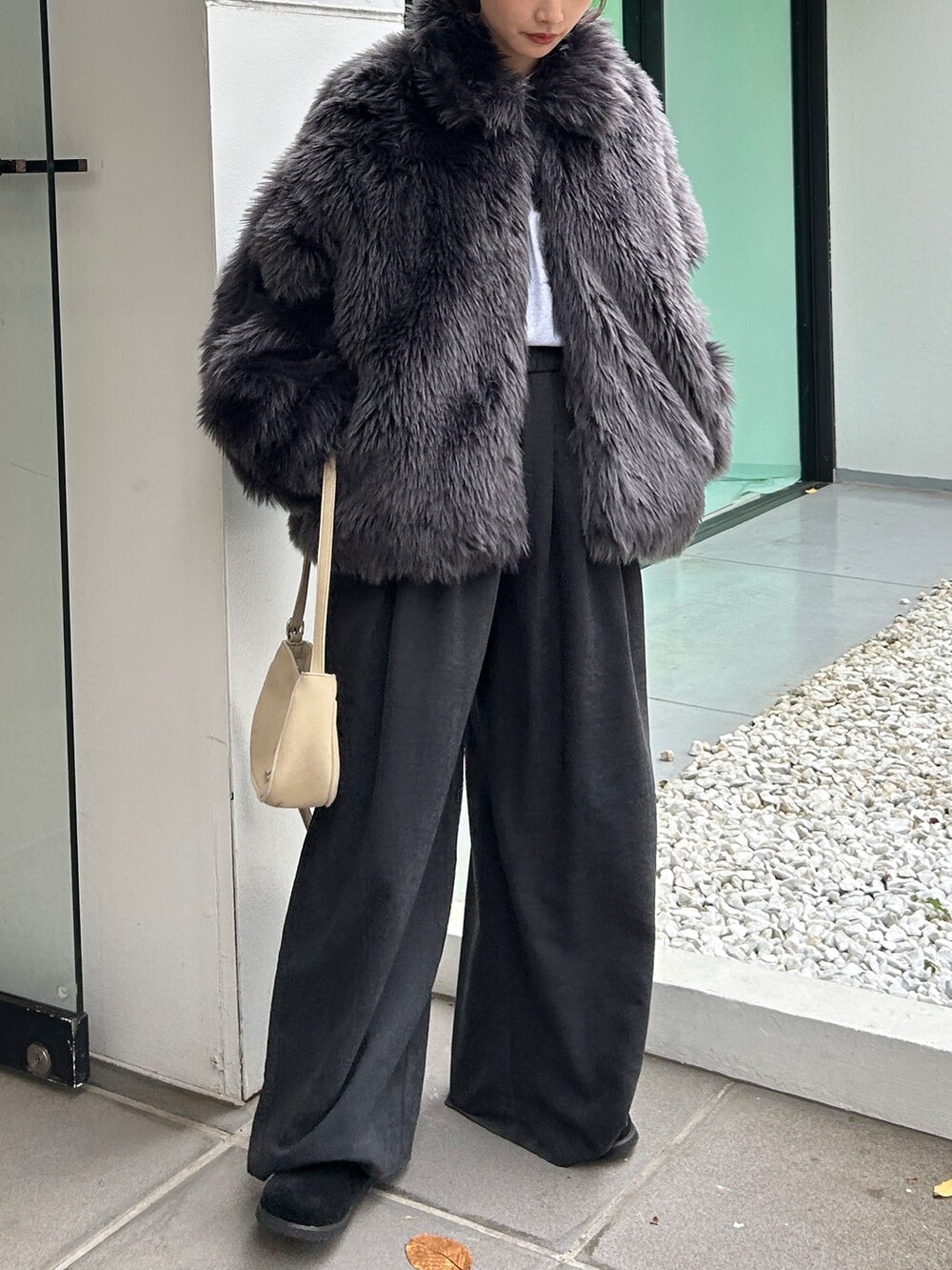 グレー系のダウンジャケット/コート、グレー系のその他パンツ、ブラック系のスリッポンを着用したレディースの秋コーディネートの6枚目の写真