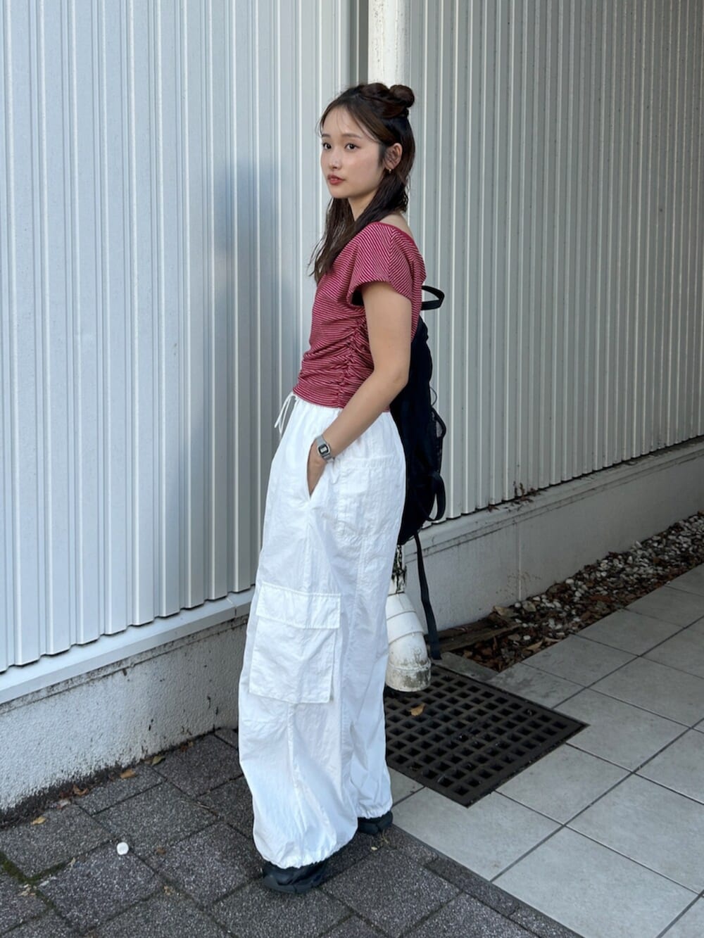 ブラック系のバックパック/リュック、ホワイト系のその他パンツ、レッド系のTシャツ/カットソーを着用したレディースの夏コーディネートの3枚目の写真