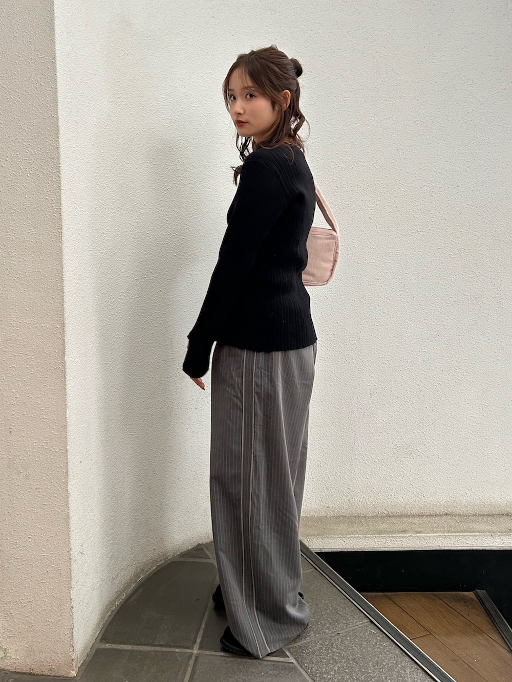 グレー系のその他パンツ、ブラック系のスリッポン、ピンク系のハンドバッグを着用したレディースの冬コーディネートの3枚目の写真