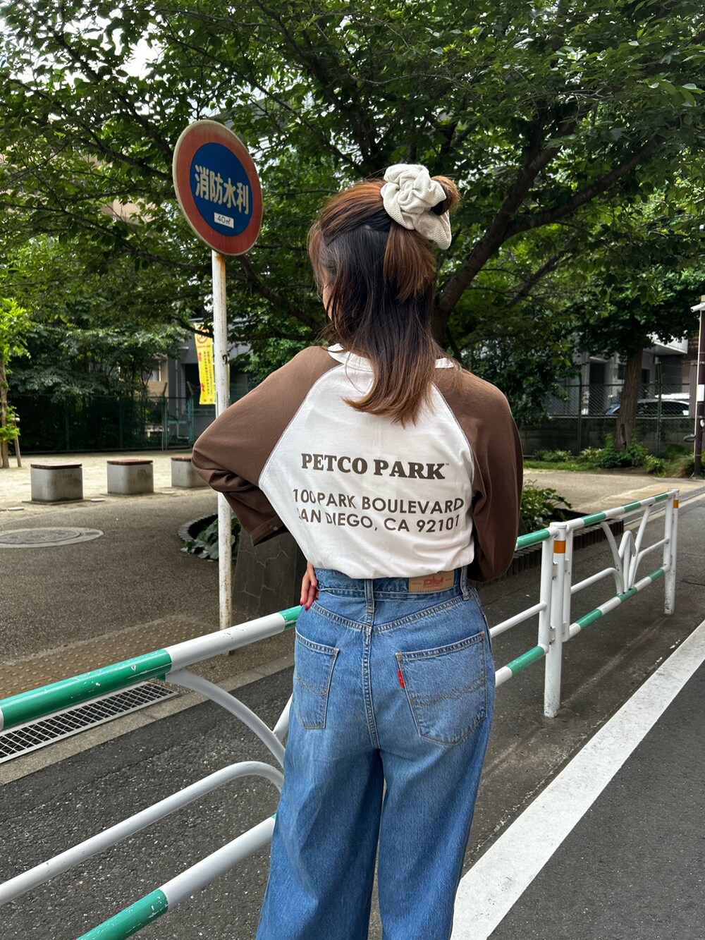 ブルー系のデニムパンツ、ベージュ系のローファー、ブラウン系のTシャツ/カットソーを着用したレディースの夏コーディネートの6枚目の写真