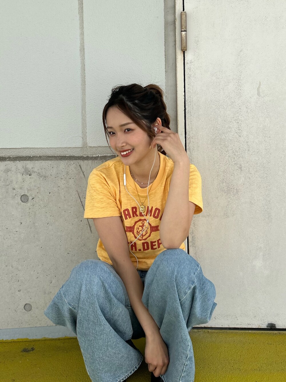 イエロー系のTシャツ/カットソー、ブルー系のデニムパンツを着用したレディースの春コーディネートの6枚目の写真
