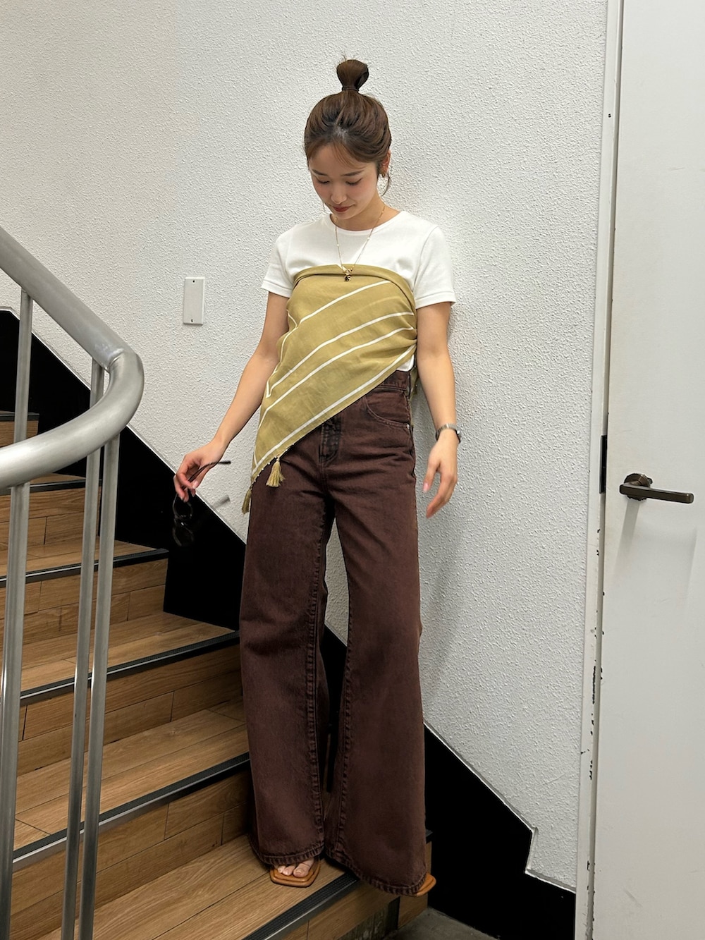 ブラウン系のデニムパンツ、ホワイト系のTシャツ/カットソー、イエロー系のバンダナ/スカーフを着用したレディースの春コーディネートの2枚目の写真