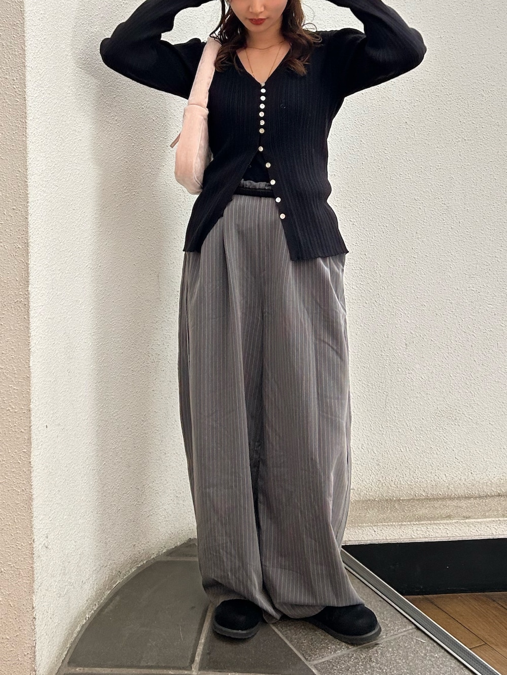 グレー系のその他パンツ、ブラック系のスリッポン、ピンク系のハンドバッグを着用したレディースの冬コーディネートの5枚目の写真