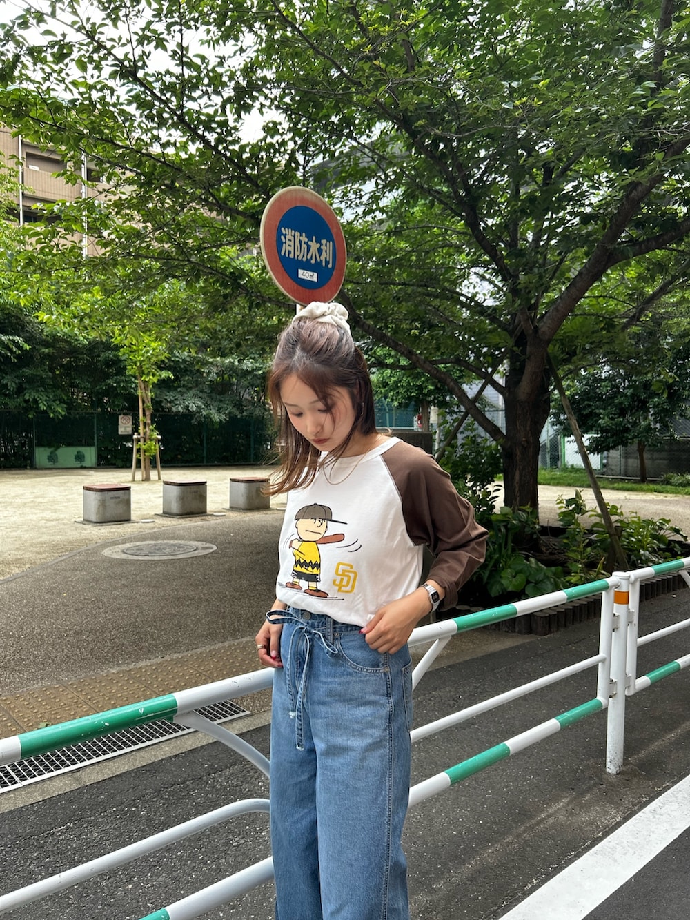 ブルー系のデニムパンツ、ベージュ系のローファー、ブラウン系のTシャツ/カットソーを着用したレディースの夏コーディネートの5枚目の写真