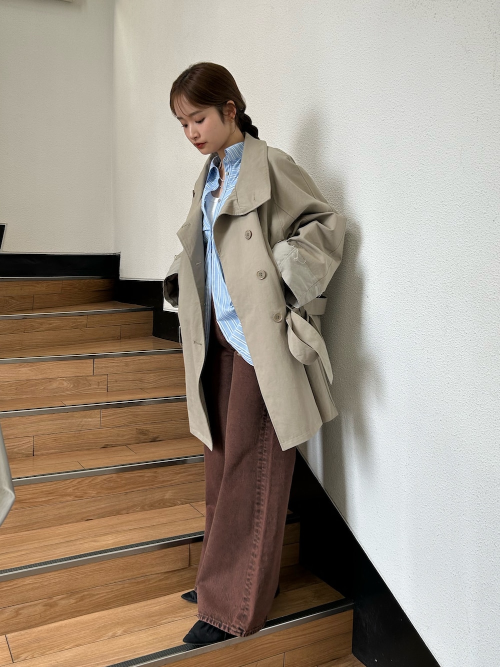 グリーン系のトレンチコート、ブラック系のパンプス、ブルー系のシャツ/ブラウスを着用したレディースの春コーディネートの4枚目の写真