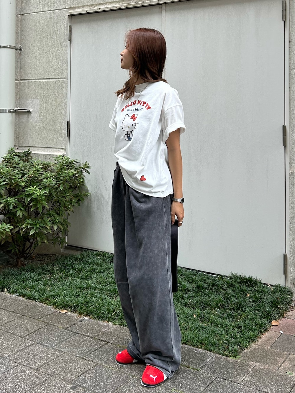 グレー系のスウェットパンツ、ブラック系のハンドバッグ、ホワイト系のTシャツ/カットソーを着用したレディースの夏コーディネートの2枚目の写真