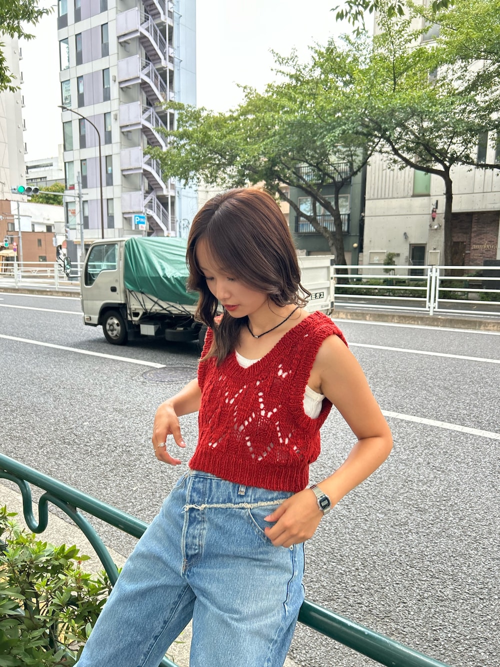 ブルー系のデニムパンツ、ゴールド系のバレエシューズ、オレンジ系のワンピースを着用したレディースの夏コーディネートの6枚目の写真