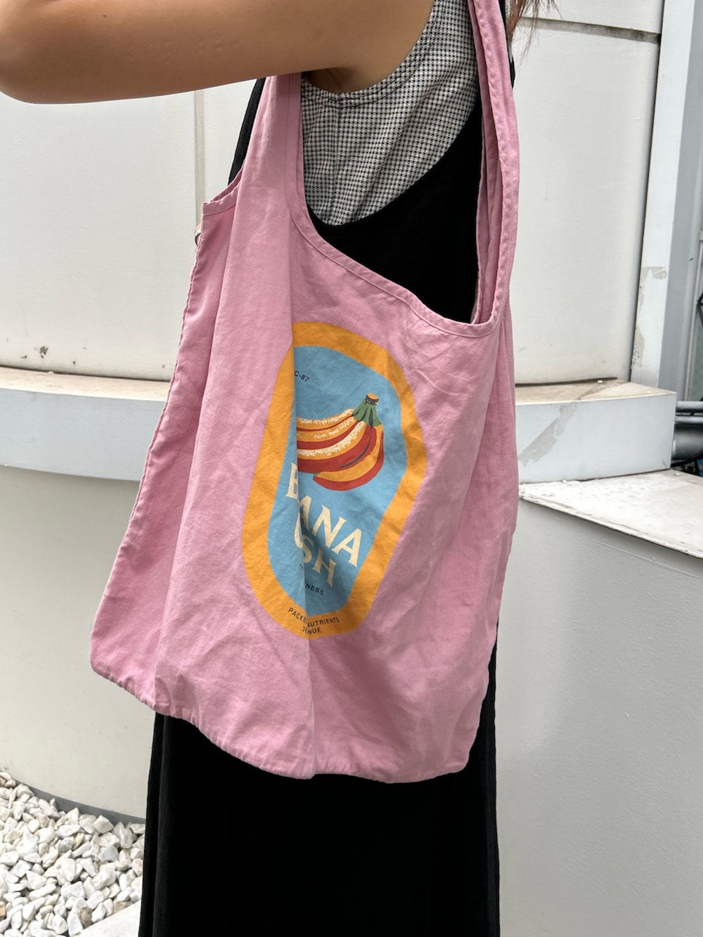 ブラック系のワンピース、ホワイト系のサンダル、ブルー系のデニムパンツを着用したレディースの夏コーディネートの5枚目の写真