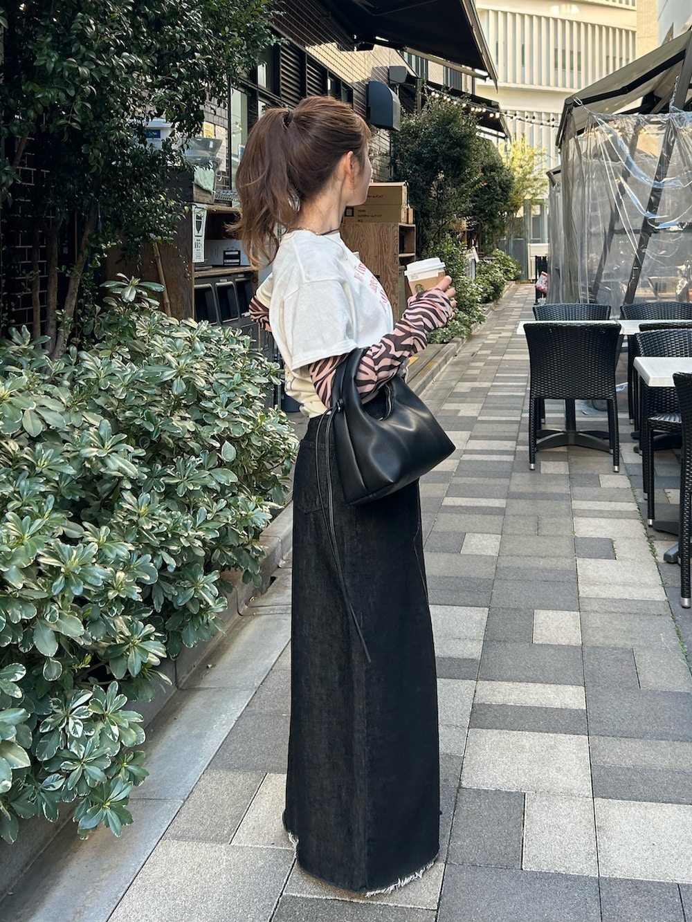 ブラック系のTシャツ/カットソー、ホワイト系のTシャツ/カットソー、ブラック系のスカートを着用したレディースの春コーディネートの5枚目の写真