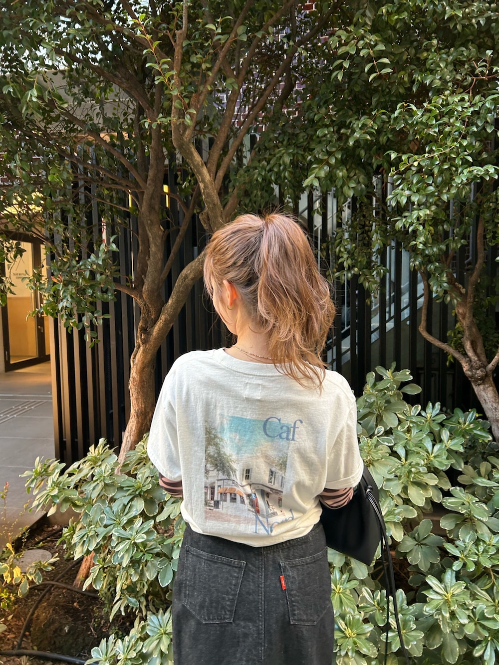 ブラック系のTシャツ/カットソー、ホワイト系のTシャツ/カットソー、ブラック系のスカートを着用したレディースの春コーディネートの8枚目の写真