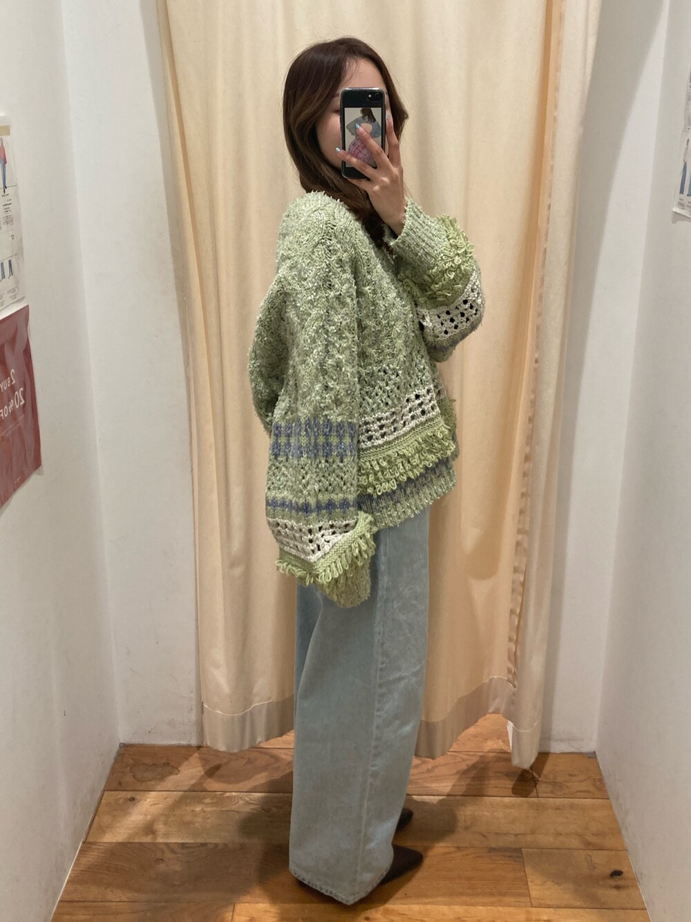 グリーン系のニット/セーター、ブルー系のデニムパンツ、ブラウン系のブーツを着用したレディースの冬コーディネートの2枚目の写真