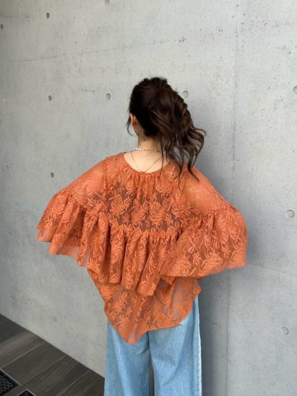 ブルー系のデニムパンツ、ブラック系のパンプス、オレンジ系のシャツ/ブラウスを着用したレディースの冬コーディネートの6枚目の写真