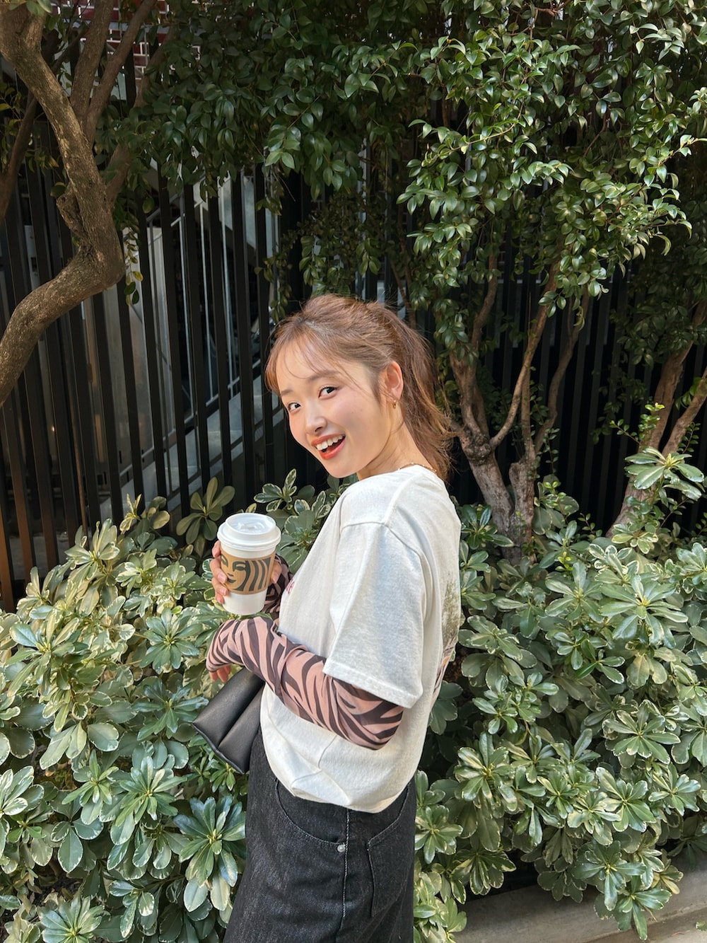 ブラック系のTシャツ/カットソー、ホワイト系のTシャツ/カットソー、ブラック系のスカートを着用したレディースの春コーディネートの6枚目の写真