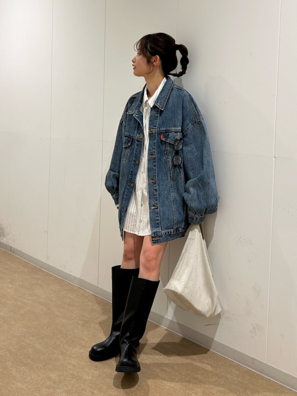 ブルー系のデニムジャケット、ホワイト系のシャツ/ブラウス、ブラック系のブーツを着用したレディースの冬コーディネートの2枚目の写真