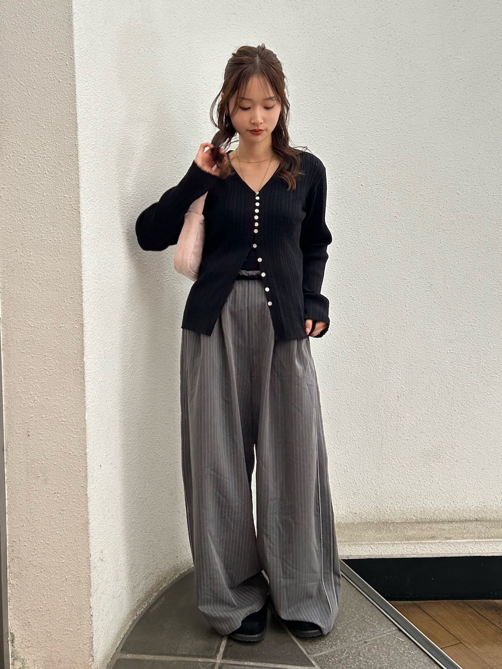 グレー系のその他パンツ、ブラック系のスリッポン、ピンク系のハンドバッグを着用したレディースの冬コーディネートの2枚目の写真