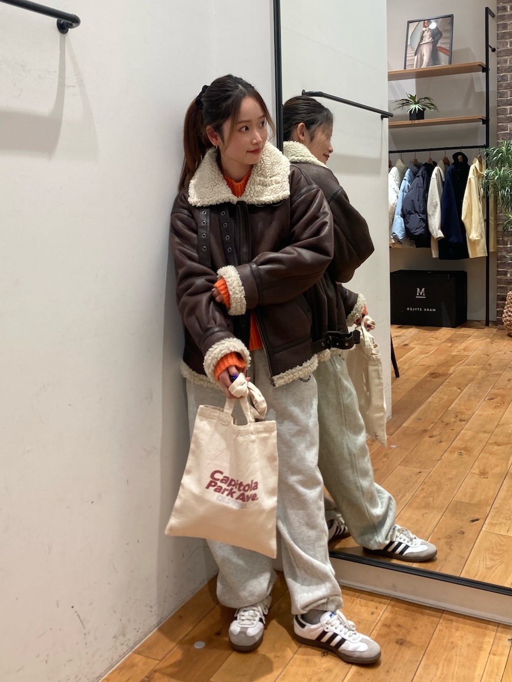 グレー系のスウェットパンツ、レッド系のトートバッグ、ブラウン系のブルゾンを着用したレディースの冬コーディネートの4枚目の写真