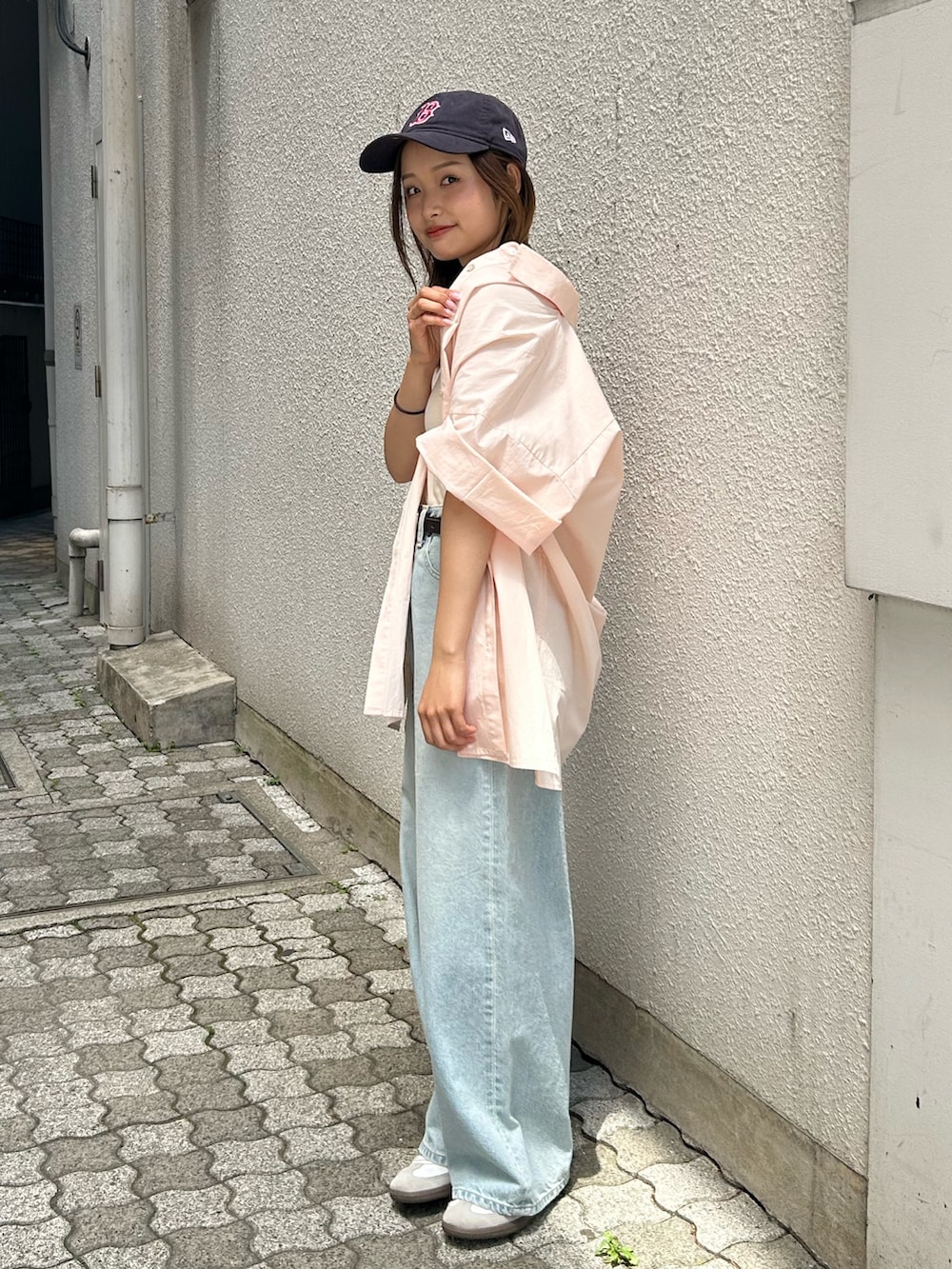 ブルー系のデニムパンツ、ピンク系のシャツ/ブラウス、ホワイト系のキャミソールを着用したレディースの春コーディネートの3枚目の写真