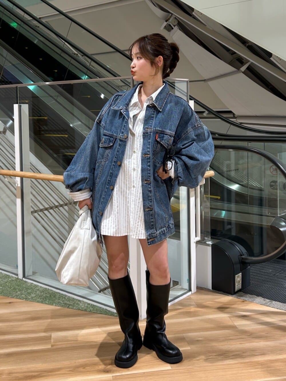 ブルー系のデニムジャケット、ホワイト系のシャツ/ブラウス、ブラック系のブーツを着用したレディースの冬コーディネートの5枚目の写真