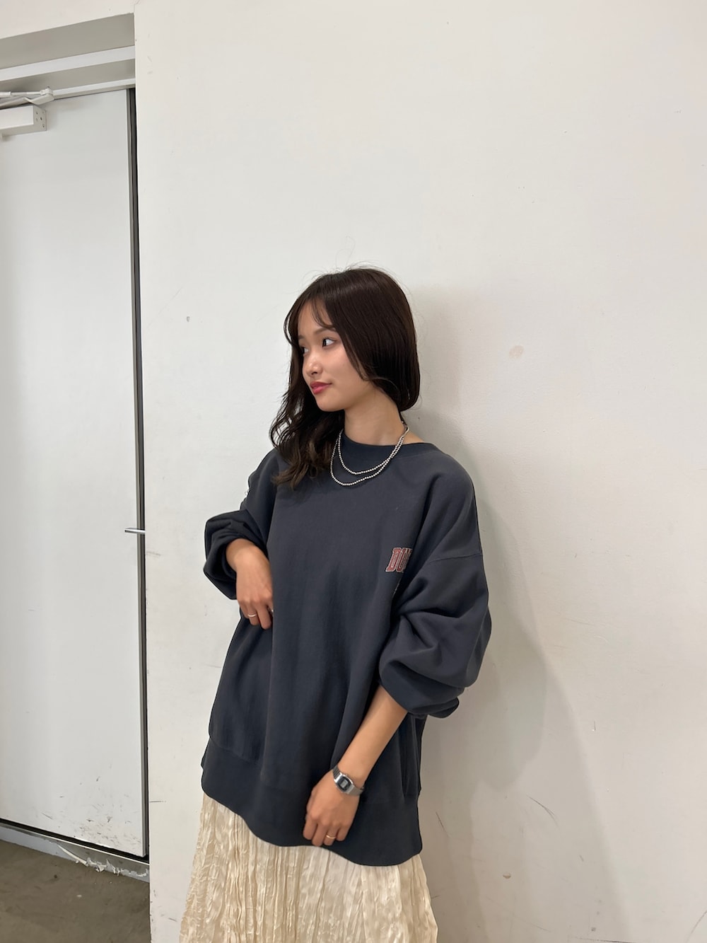 グレー系のスウェット、ホワイト系のスカート、ブラウン系のブーツを着用したレディースの秋コーディネートの5枚目の写真