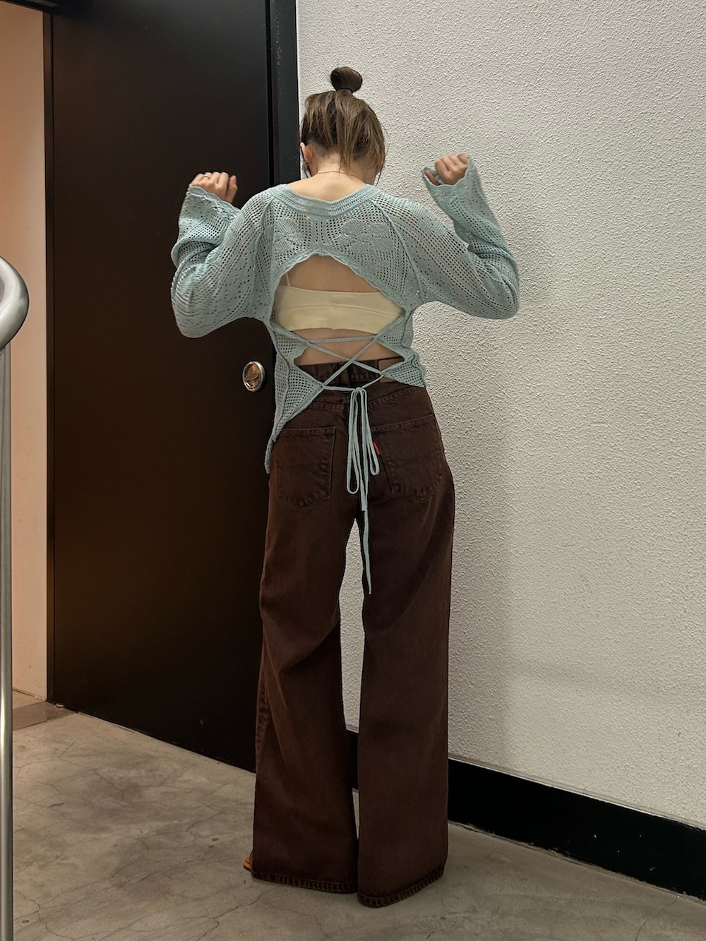 ブラウン系のデニムパンツ、ブルー系のニット/セーターを着用したレディースの春コーディネートの5枚目の写真