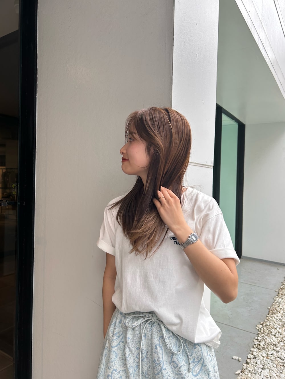 ブルー系のデニムパンツ、ホワイト系のパンプス、ホワイト系のTシャツ/カットソーを着用したレディースの春コーディネートの6枚目の写真