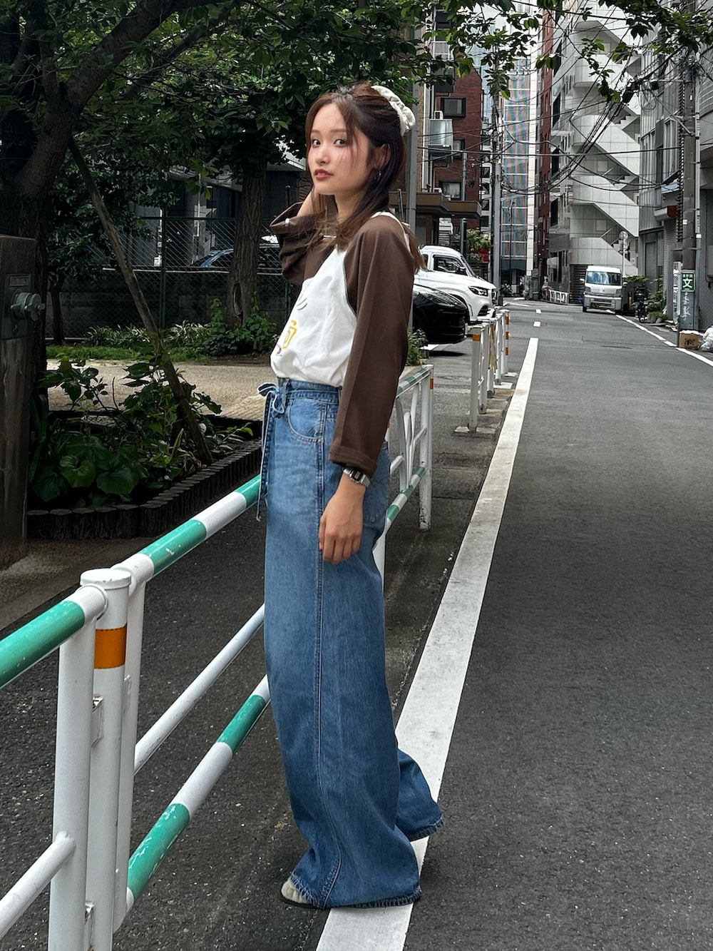 ブルー系のデニムパンツ、ベージュ系のローファー、ブラウン系のTシャツ/カットソーを着用したレディースの夏コーディネートの4枚目の写真