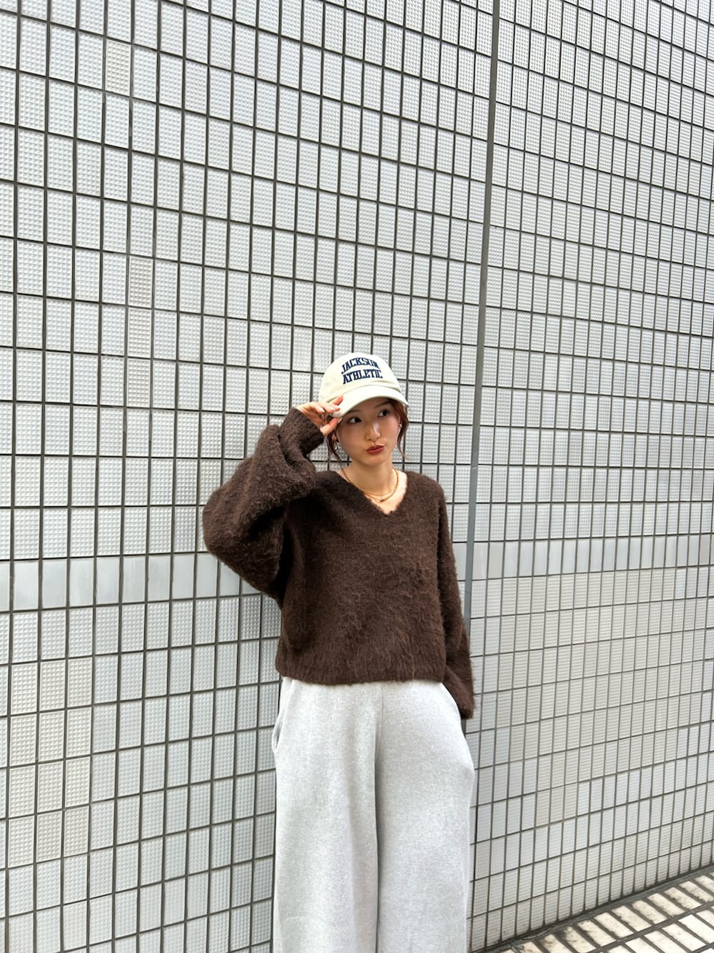 ホワイト系のスニーカー、ブラウン系のニット/セーター、グレー系のその他パンツを着用したレディースの秋コーディネートの7枚目の写真