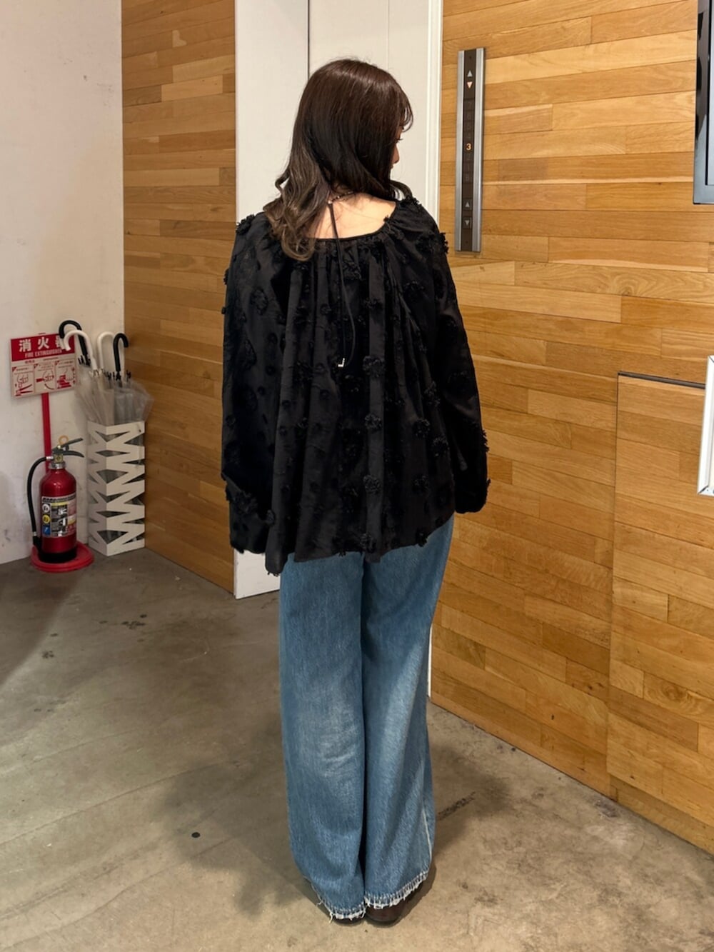 ブルー系のデニムパンツ、ブラック系のシャツ/ブラウス、ベージュ系のローファーを着用したレディースの秋コーディネートの5枚目の写真