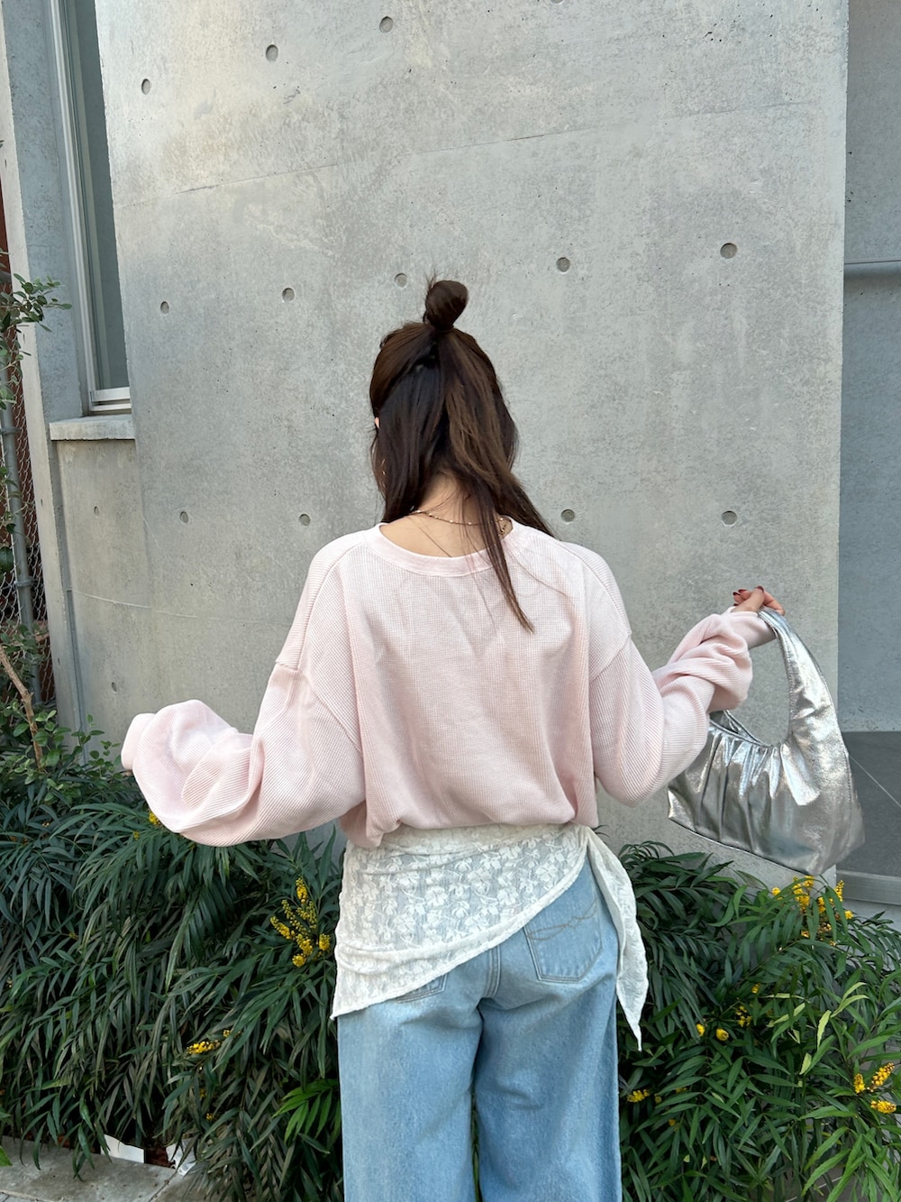 ブルー系のデニムパンツ、ブラック系のサンダル、シルバー系のハンドバッグを着用したレディースの冬コーディネートの7枚目の写真