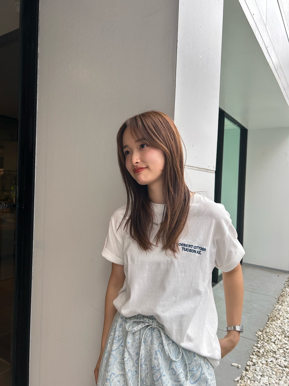 ブルー系のデニムパンツ、ホワイト系のパンプス、ホワイト系のTシャツ/カットソーを着用したレディースの春コーディネートの5枚目の写真