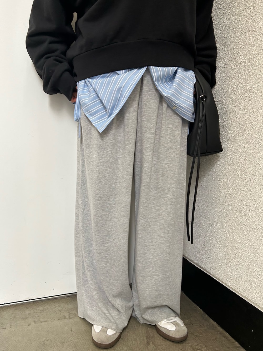 ブラック系のスウェット、ブルー系のシャツ/ブラウス、ブラック系のハンドバッグを着用したレディースの春コーディネートの7枚目の写真