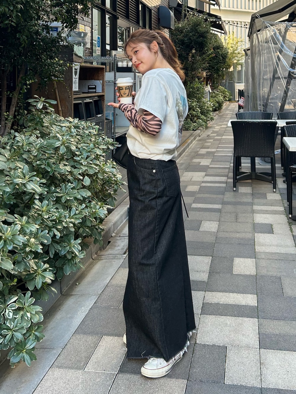 ブラック系のTシャツ/カットソー、ホワイト系のTシャツ/カットソー、ブラック系のスカートを着用したレディースの春コーディネートの3枚目の写真