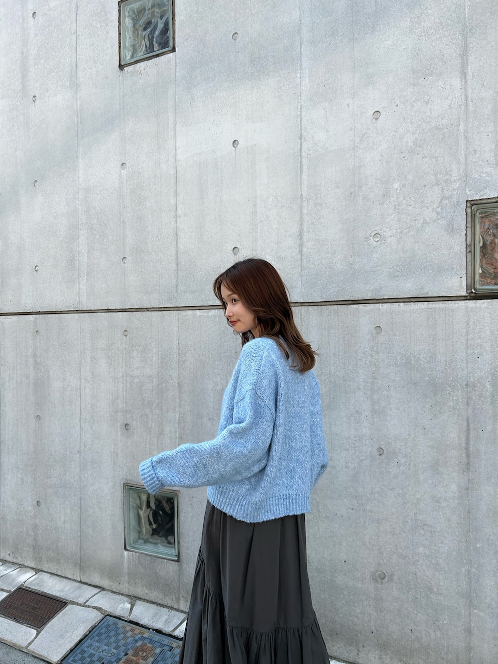 グレー系のスカート、ブラック系のネックレスを着用したレディースの秋コーディネートの6枚目の写真