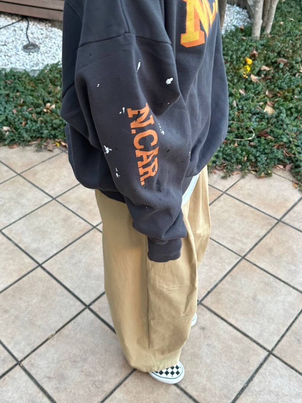 グレー系のスウェット、ベージュ系のチノパンツ、ホワイト系のTシャツ/カットソーを着用したレディースの冬コーディネートの5枚目の写真