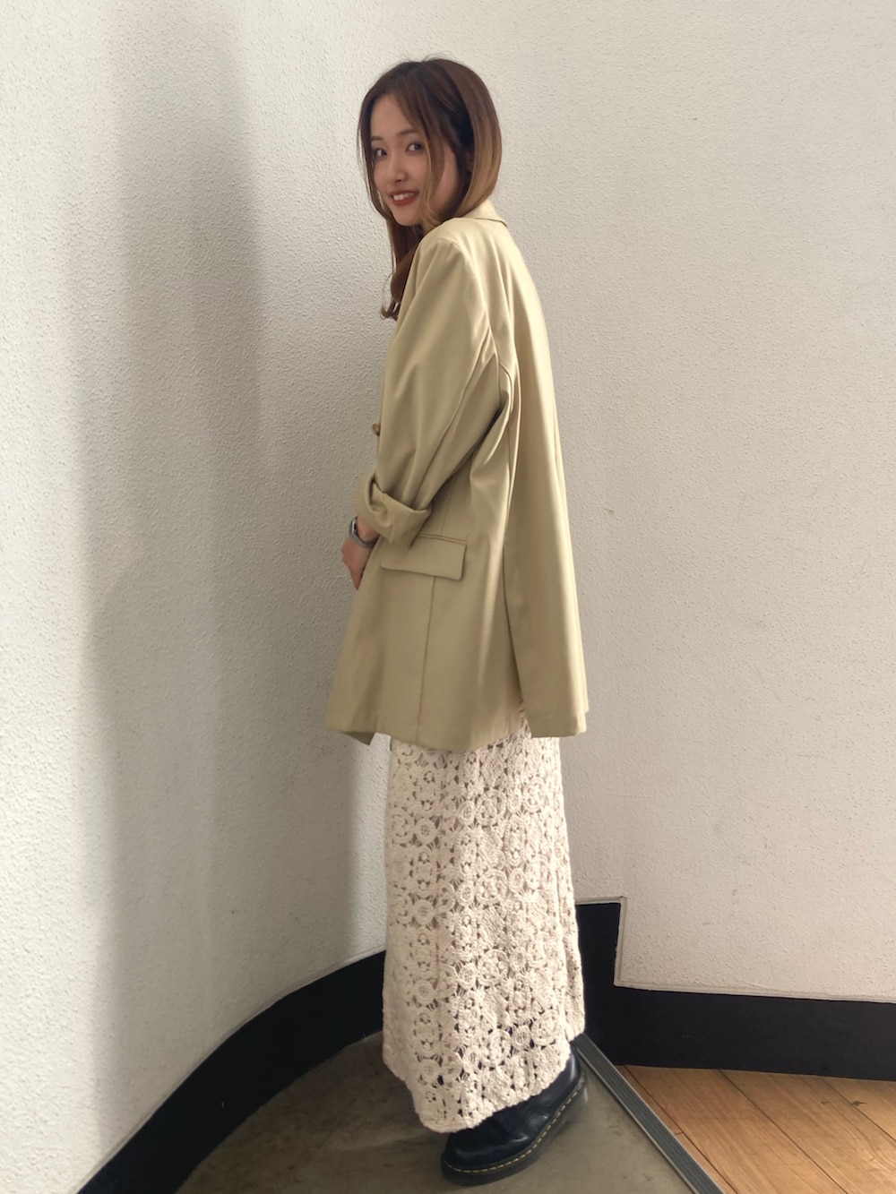 ベージュ系のテーラードジャケット、ベージュ系のワンピース、ゴールド系のネックレスを着用したレディースの春コーディネートの4枚目の写真