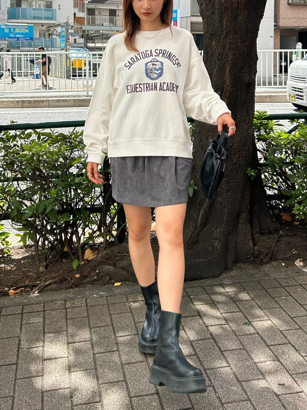 ホワイト系のスウェット、グレー系のスカート、ブラック系のブーツを着用したレディースの秋コーディネートの3枚目の写真