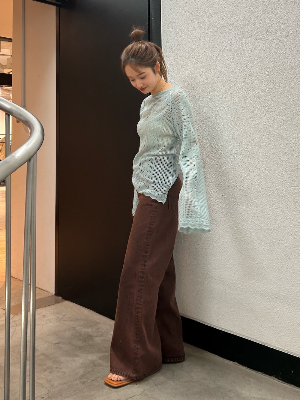 ブラウン系のデニムパンツ、ブルー系のニット/セーターを着用したレディースの春コーディネートの3枚目の写真