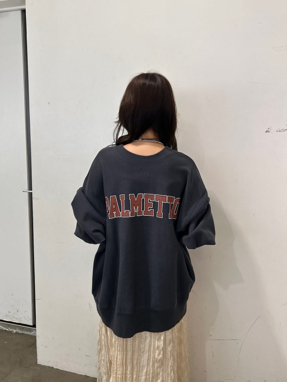 グレー系のスウェット、ホワイト系のスカート、ブラウン系のブーツを着用したレディースの秋コーディネートの6枚目の写真