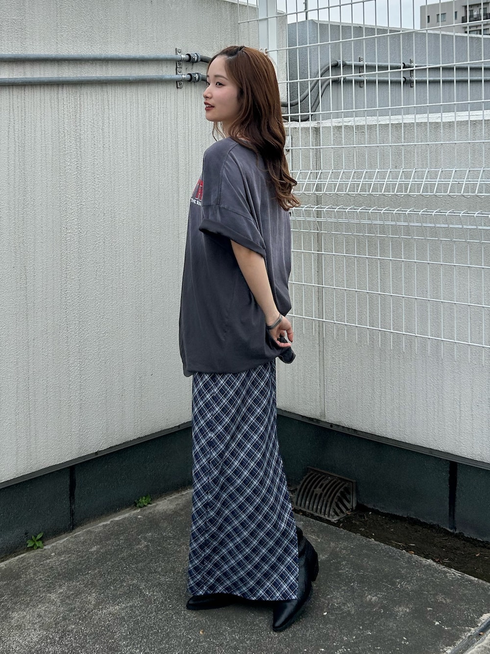 グレー系のTシャツ/カットソー、ブルー系のスカート、ブラック系のブーツを着用したレディースの春コーディネートの4枚目の写真