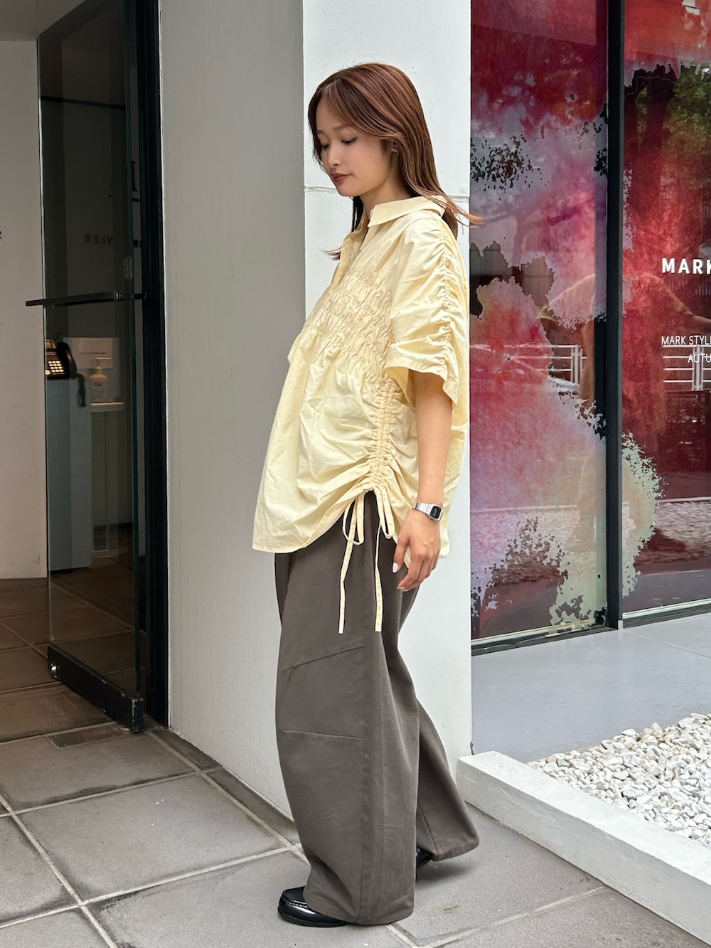 イエロー系のシャツ/ブラウス、グレー系のチノパンツを着用したレディースの夏コーディネートの3枚目の写真