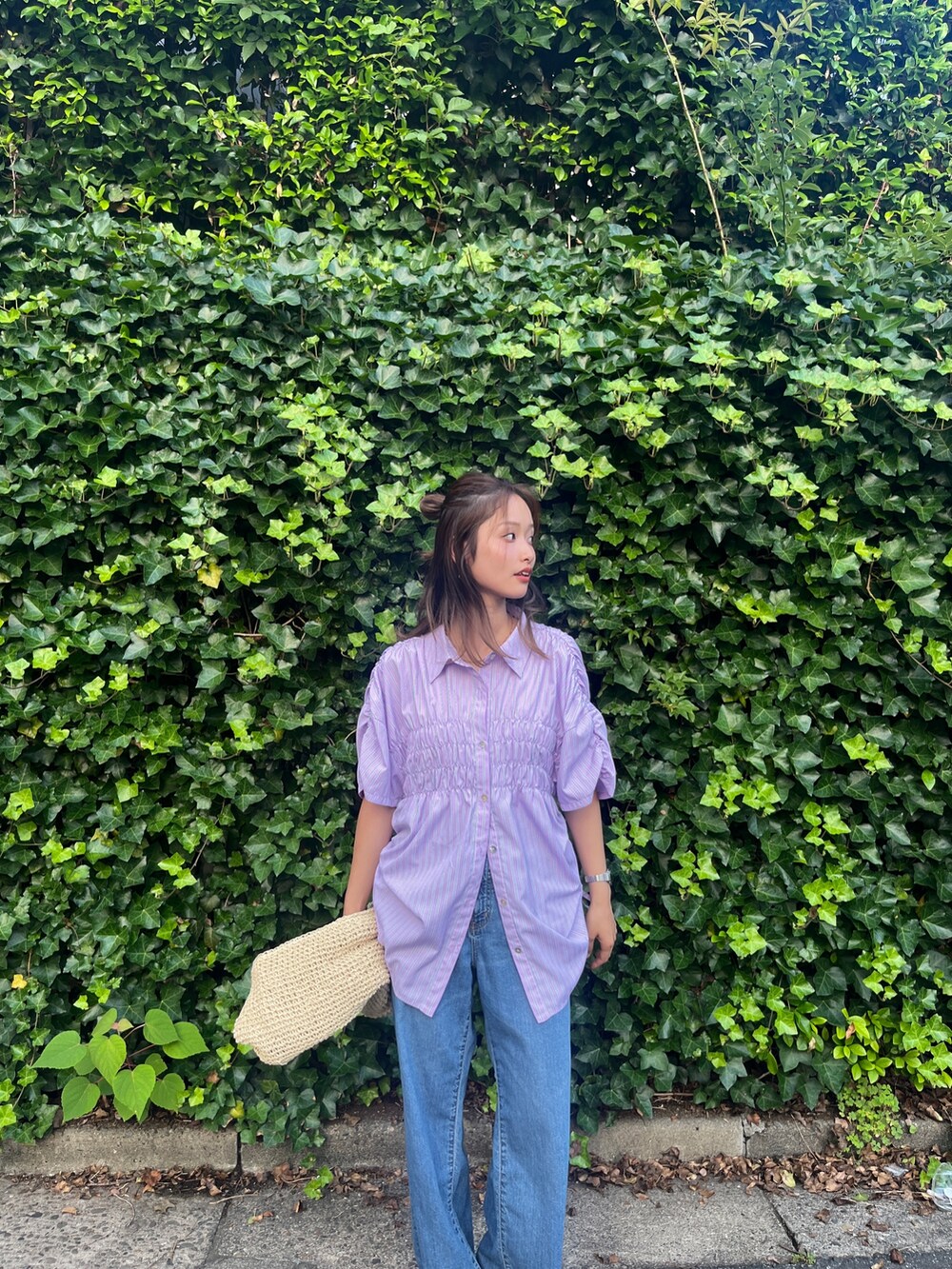 ブルー系のデニムパンツ、ブラック系のサンダル、パープル系のシャツ/ブラウスを着用したレディースの夏コーディネートの4枚目の写真