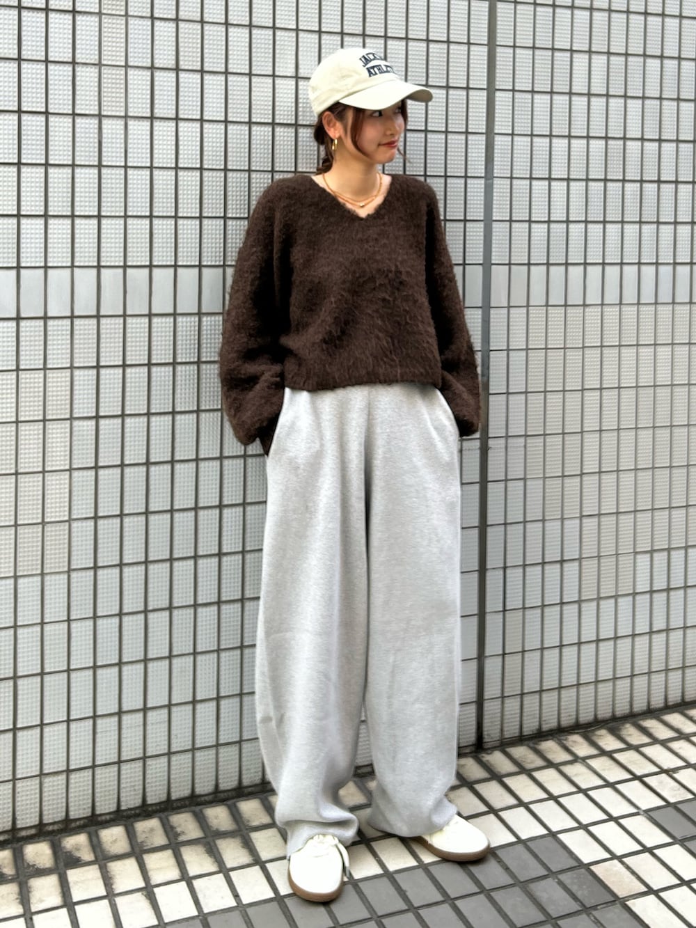 ホワイト系のスニーカー、ブラウン系のニット/セーター、グレー系のその他パンツを着用したレディースの秋コーディネートの4枚目の写真