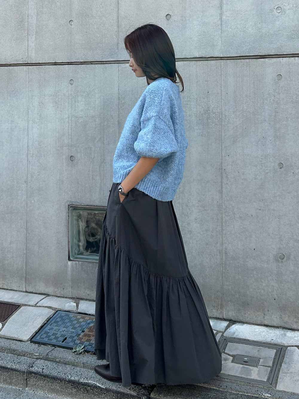グレー系のスカート、ブラック系のネックレスを着用したレディースの秋コーディネートの4枚目の写真