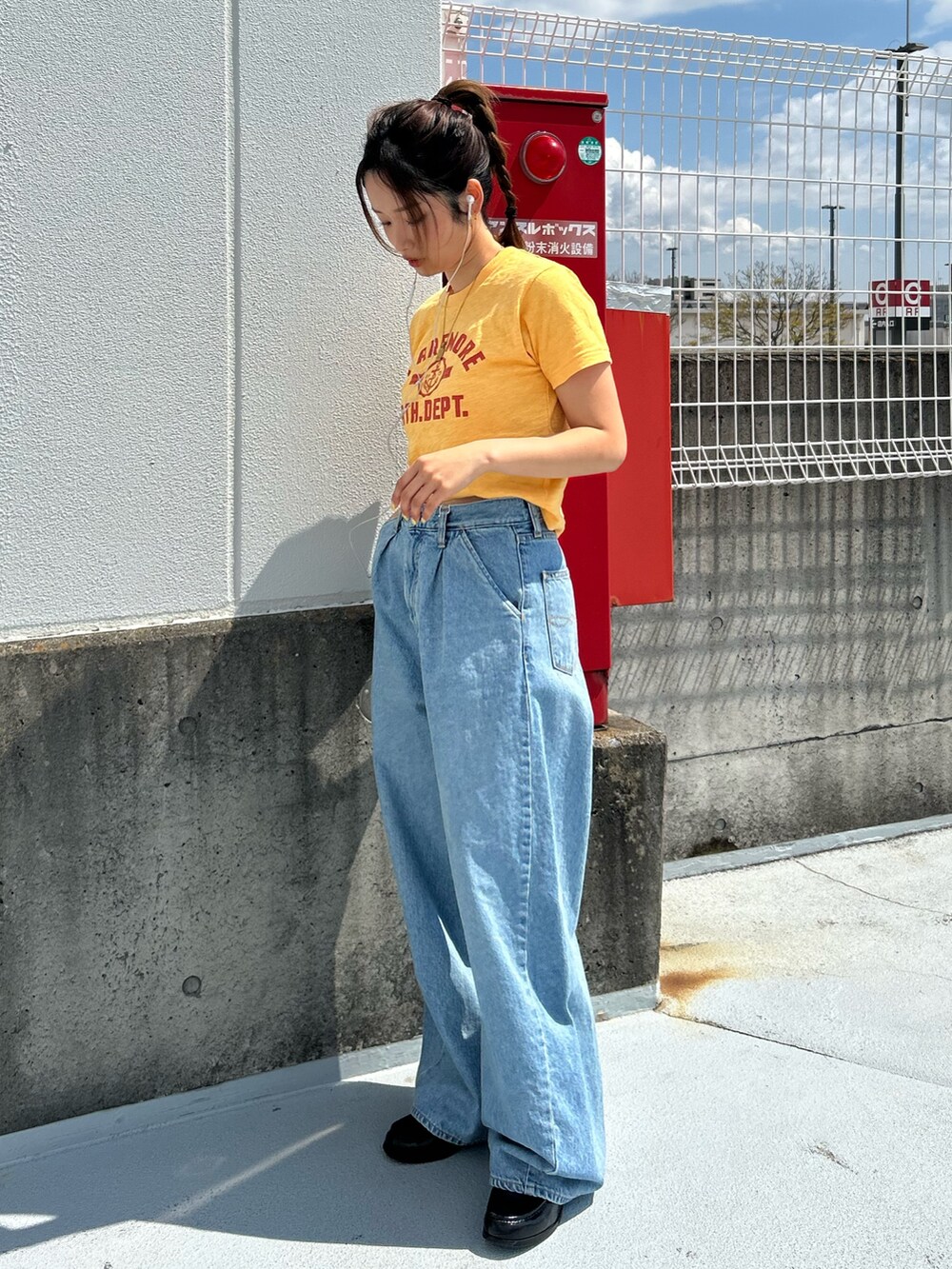 イエロー系のTシャツ/カットソー、ブルー系のデニムパンツを着用したレディースの春コーディネートの2枚目の写真