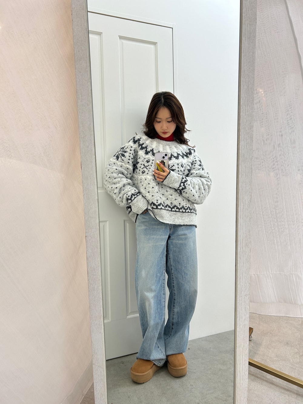 グレー系のニット/セーター、ブルー系のデニムパンツ、レッド系のニット/セーターを着用したレディースの冬コーディネートの7枚目の写真